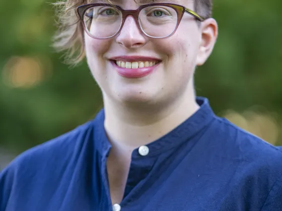 Woman with cropped red hair and glasses