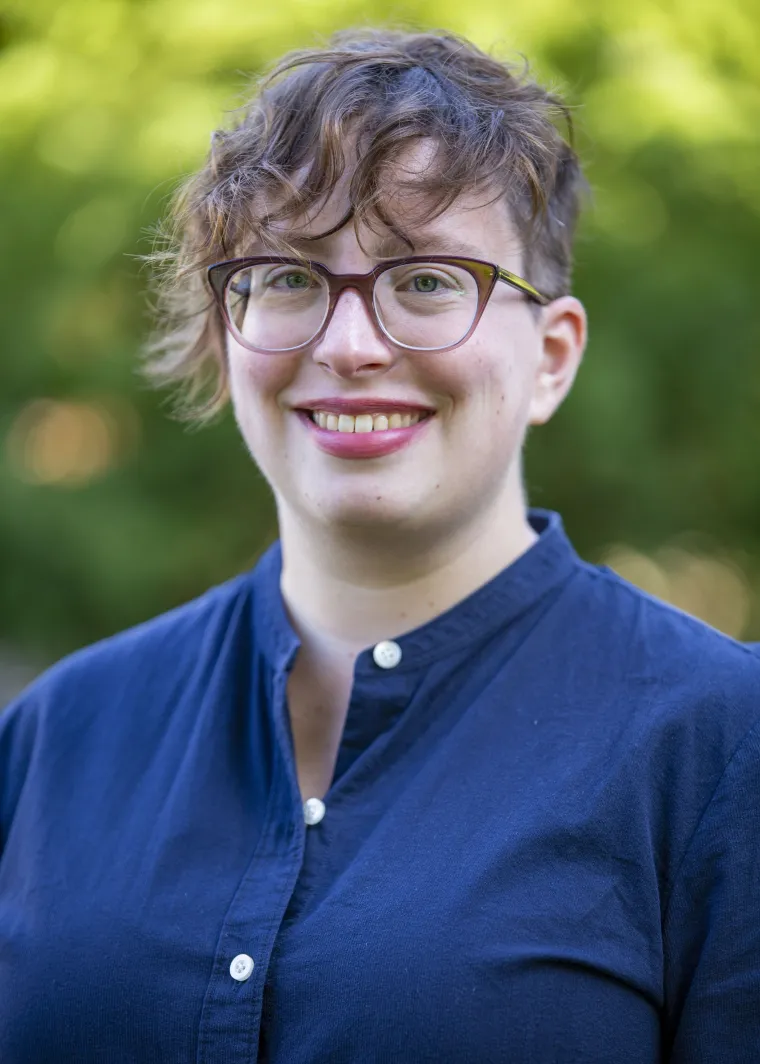 Woman with cropped red hair and glasses